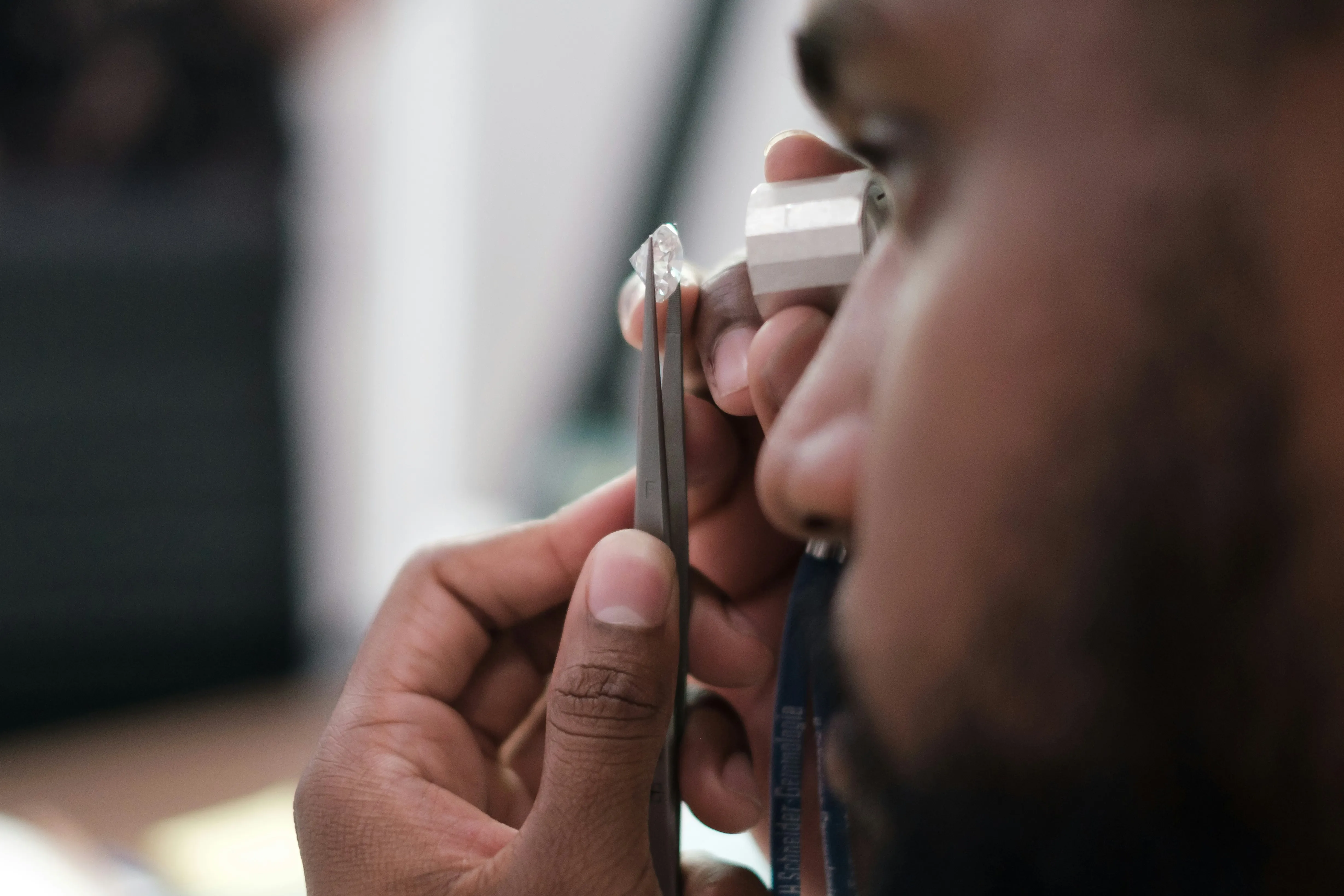 Expert examining diamond with loupe